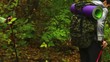 Yong hiker helps to a girl to cross a stream