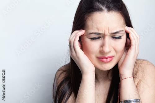 Photo: Headache concept - woman suffering a migraine Headache concept - woman suffering a migraine