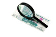 Banknote and magnifying glass isolated