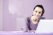 Portrait of a young female relaxing in bed while using laptop: c