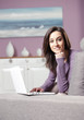 portrait of young woman on the sofa using laptop