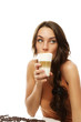 schöne frau trinkt latte macchiato kaffee und schaut zur seite