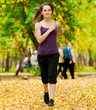 Photo: A young girl running in autumn park A young girl running in autumn park