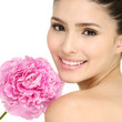 Young girl holding pink peony flower in her hands
