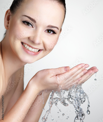 Foto: Smiling woman washing face with water Smiling woman washing face with water