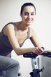 A young woman riding an exercise bike