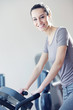 portrait of  young woman riding an exercise bike