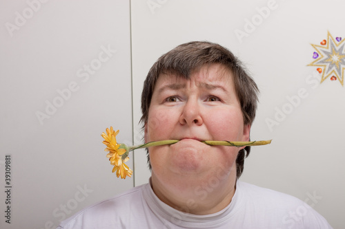 Photo: Geistig behinderte Frau hält Blume im Mund Geistig behinderte Frau hält Blume im Mund