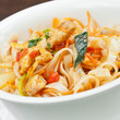 Spicy swordfish pieces with noodles and spring onions