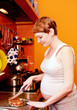 Photo: Pregnant woman with cake in kitchen Pregnant woman with cake in kitchen