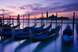 Gondolas moored by Saint Mark's square at dawn in Venice