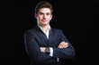 Fashion young businessman black suit on dark  background