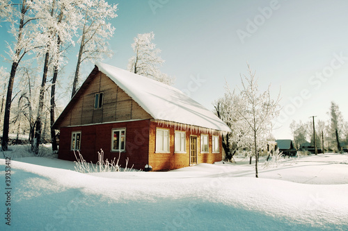 Photo: Trees in hoarfrost and red house on morning of winter village Trees in hoarfrost and red house on morning of winter village
