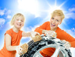 Cute child and young woman cleaning a wheel outdoors