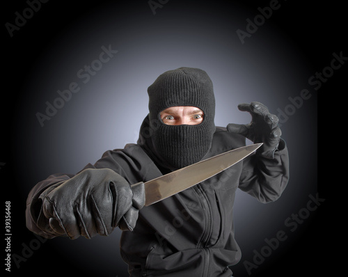 Foto: Masked criminal holding a knife Masked criminal holding a knife