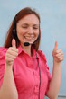 Woman with headset gesturing thumbs up