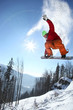 Snowboarder jumping against blue sky