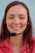 Redhead young woman at helpdesk center, smiling