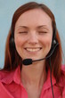 Redhead young woman at helpdesk center, smiling