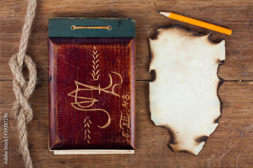 Foto: Antique Old Notebook and Burnt Paper on Wood background Antique Old Notebook and Burnt Paper on Wood background