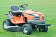 Petrol lawn mower with the lights on on green grass background