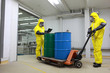 Photo: Two specialists in protective uniforms dealing with barrels Two specialists in protective uniforms dealing with barrels