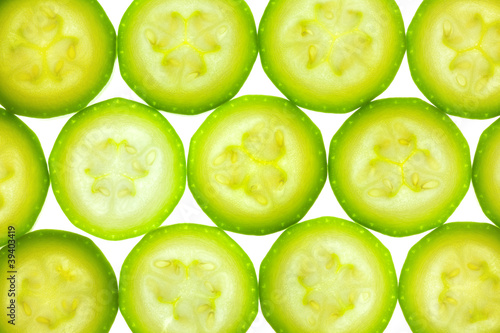 Foto: Slices of zucchini or courgette isolated on white / back lit Slices of zucchini or courgette isolated on white / back lit
