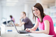 Photo: in the library - pretty female student with laptop and books in the library - pretty female student with laptop and books