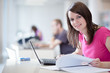 Photo: in the library - pretty female student with laptop and books in the library - pretty female student with laptop and books