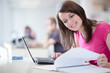 Photo: in the library - pretty female student with laptop and books in the library - pretty female student with laptop and books
