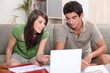 Young couple sitting on a sofa with a laptop