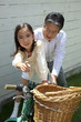 自転車に乗る練習をする孫娘と自転車を支える祖父