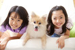 ポメラニアンと笑顔の女の子2人