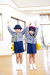 手を繋いで両手を挙げる幼稚園児男女