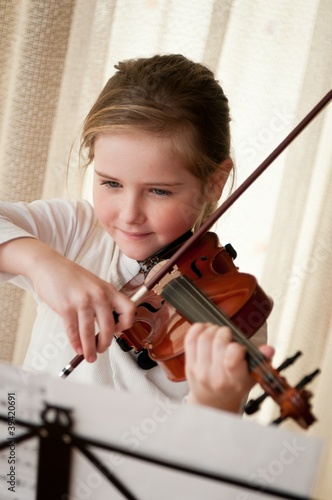 Photo: Child playing violin at home Child playing violin at home