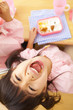 Foto: お弁当を食べながらおどける幼稚園女児 お弁当を食べながらおどける幼稚園女児
