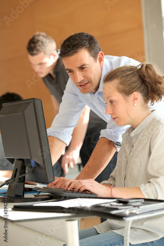 Foto: Teacher helping student girl with project Teacher helping student girl with project