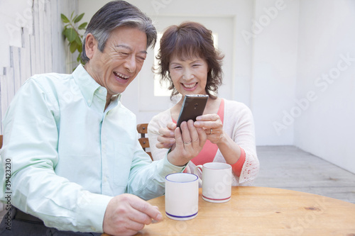 Photo: スマートフォンを触る笑顔のシニアカップル スマートフォンを触る笑顔のシニアカップル