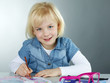 Smiling cute child is painting pictures for art lessons