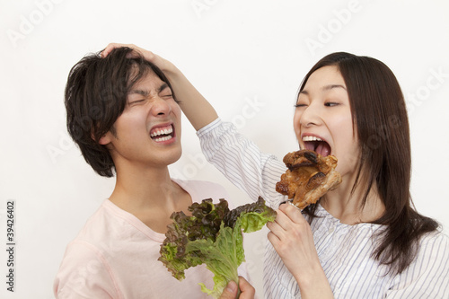 Photo: 野菜を持った男性と骨付き肉を持った女性 野菜を持った男性と骨付き肉を持った女性