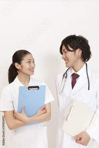 Photo: カルテを持って見つめ合う医師と看護師 カルテを持って見つめ合う医師と看護師