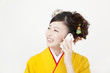 スマートフォンで電話をする振袖姿の女性