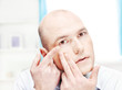 Photo: man putting contact lens in his eye man putting contact lens in his eye