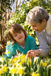 A girl with Down syndrome and her grandmother in a garden.