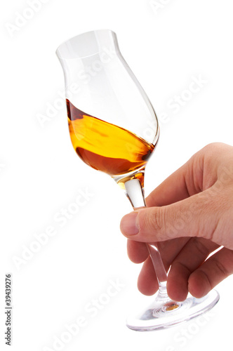 Photo: glass of brandy or whisky in the hand glass of brandy or whisky in the hand