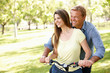 Photo: Couple with bike in park Couple with bike in park