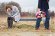 Photo: Man walking away while woman sitting in sorrow on bench Man walking away while woman sitting in sorrow on bench