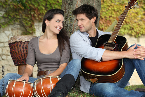 Photo: couple playing music in the park couple playing music in the park