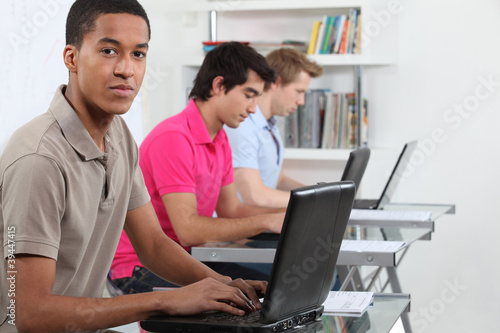 Photo: Young men working on their assignments in a computer lab Young men working on their assignments in a computer lab