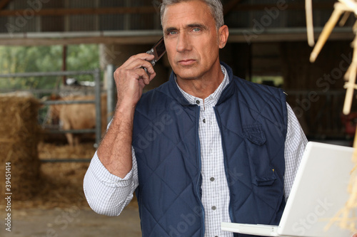 Photo: farmer with mobile phone and laptop farmer with mobile phone and laptop